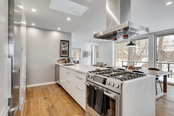 Contemporary kitchen featuring a central island and large windows with a snowy view outside.