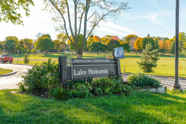 Lake Nokomis park entrance sign with fall colors in the background.