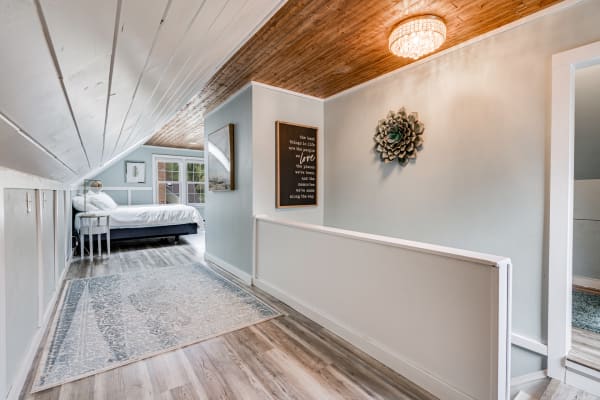 Cozy hallway with light blue walls and a glimpse of a bedroom at the end.