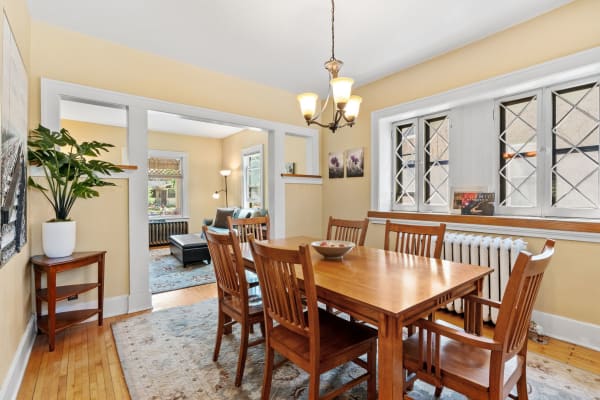 Inviting dining area featuring a wooden table, chairs, and a decorative plant.