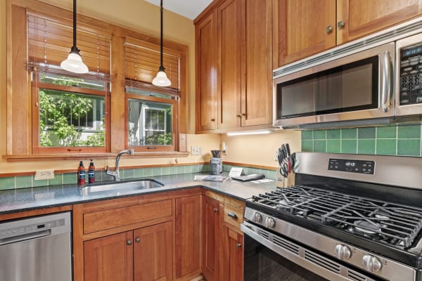 Cozy kitchen featuring wooden cabinets and stainless steel appliances under natural light.