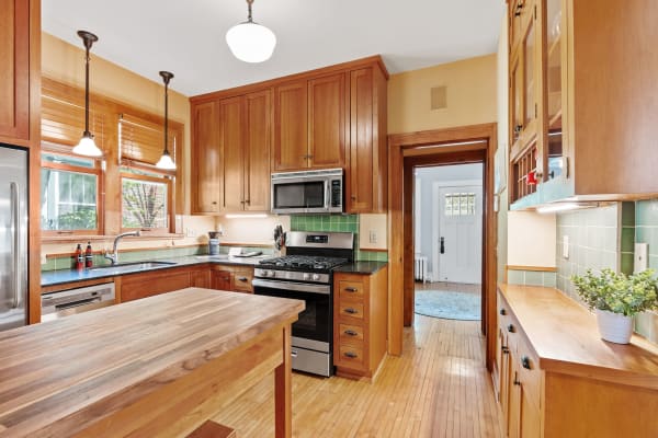 A cozy kitchen with wooden cabinetry, dark countertops, and a central island.