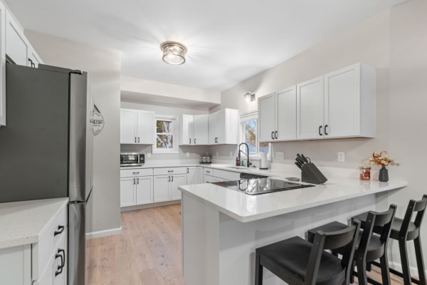 Modern kitchen with white cabinets, stainless steel appliances, and a central island.