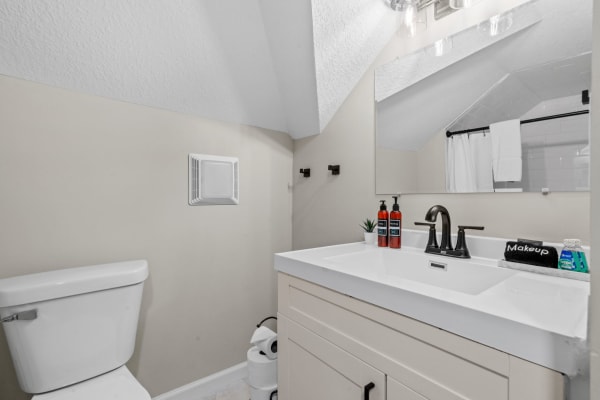 Interior view of a cozy bathroom showing a white toilet, modern vanity with a sink, and elegant fixtures.
