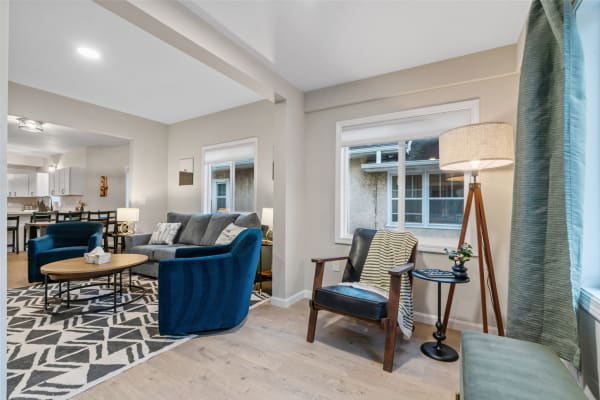 Cozy living room with blue chairs, grey sofa, and a circular coffee table.