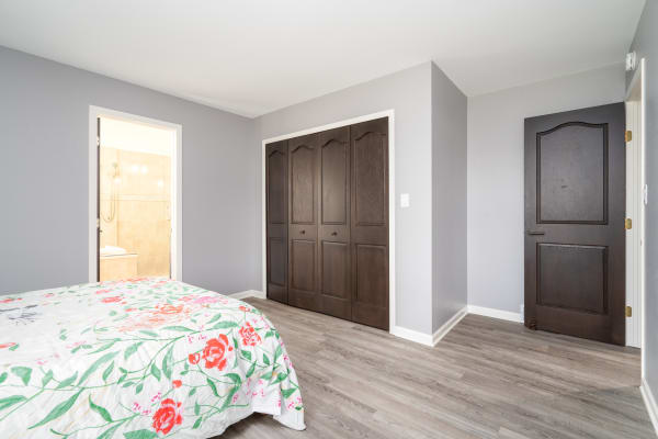 Modern bedroom with floral bedding and dark wood accents.