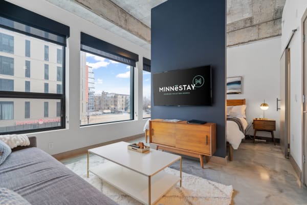 Stylish interior of a modern vacation rental with sofa, coffee table, and view of the outdoors.