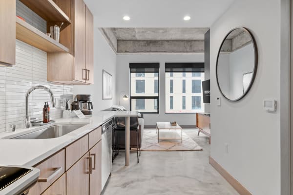 Interior view of a modern apartment featuring a kitchen and living area with large windows.