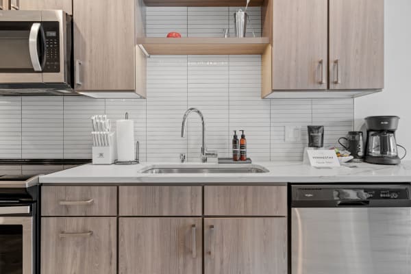 Modern kitchen with wood cabinets, stainless steel appliances, and a clean countertop.
