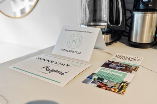 Countertop displaying promotional materials for MINNESTAY vacation rentals, including a card and a brochure.