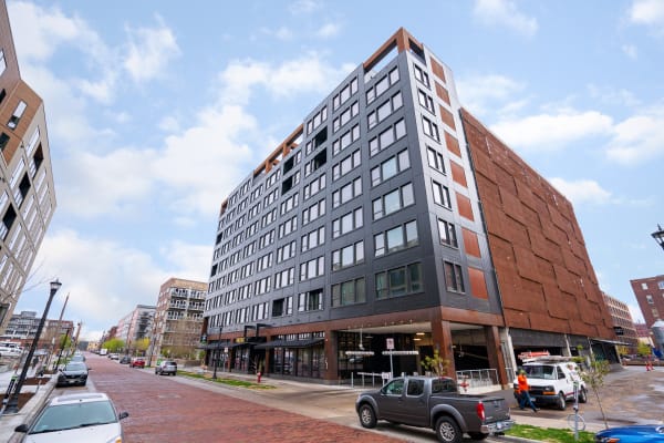 Modern building with large windows and rust-colored accents on a city street.