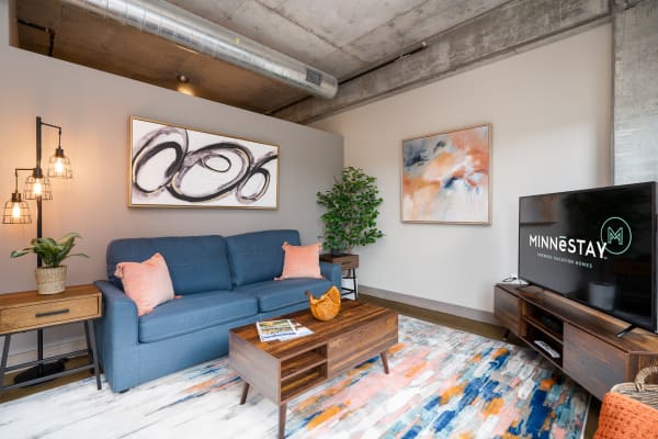 Modern living room with blue sofa, abstract artwork, and decorative elements