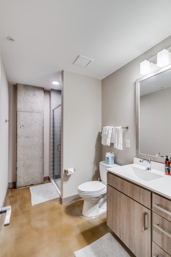 Modern bathroom interior with a wooden vanity and glass shower