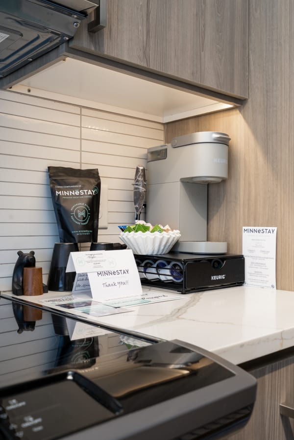 A modern kitchenette with a coffee maker and welcome amenities in a vacation rental.