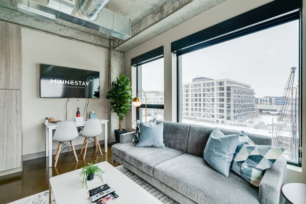 Cozy contemporary living room with a gray sofa, decorative pillows, and a workspace.