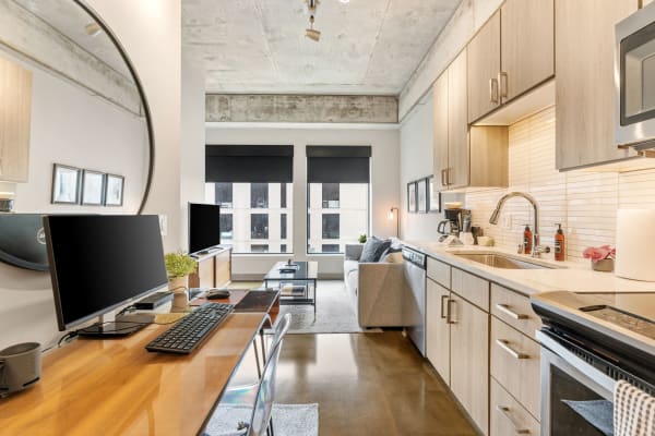 Modern studio apartment with kitchen and living area, showcasing contemporary design and furnishings.