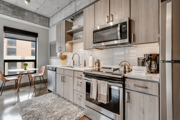 Modern kitchen with stainless steel appliances and cozy dining setup.