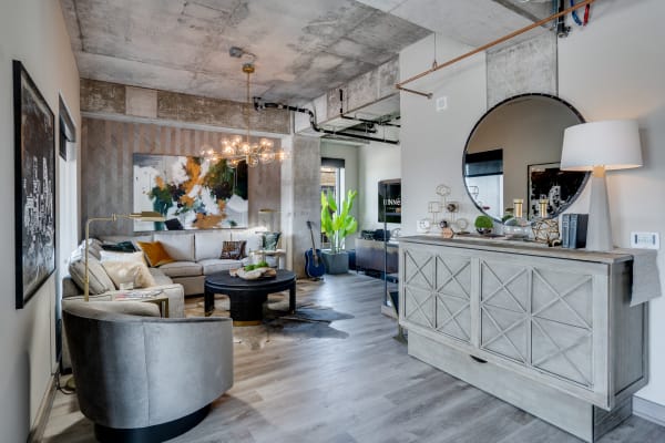 Modern living room with a gray sectional sofa, abstract art, and stylish decor.