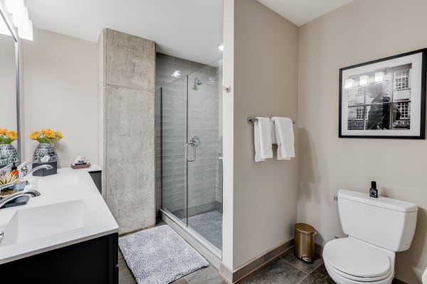 Modern bathroom with double sinks, glass shower, and neutral tones.