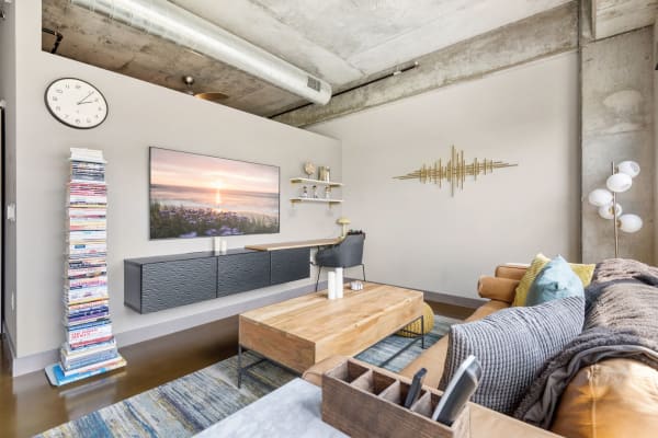Modern living room featuring a mounted TV, comfortable couch, and decorative shelves.