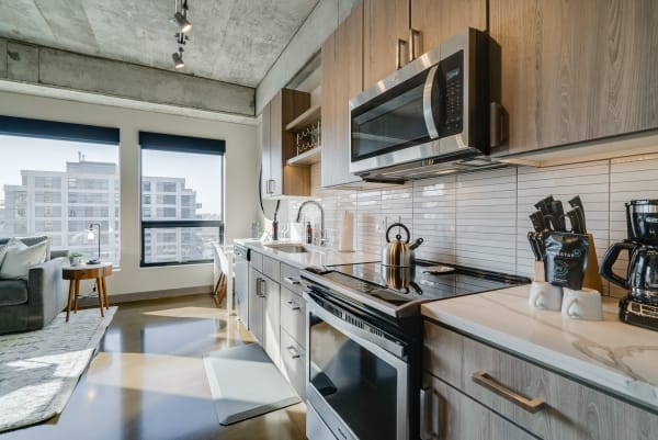Modern kitchen featuring wooden cabinetry and stainless steel appliances.