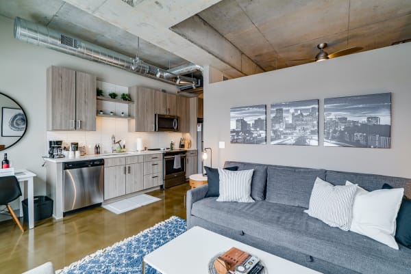 Modern apartment living space with a kitchen and sitting area.