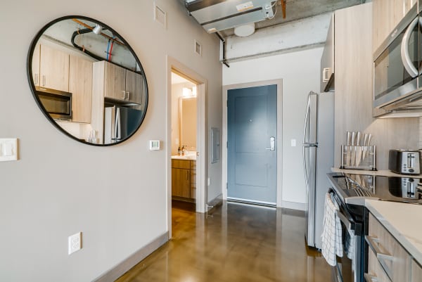 Modern kitchen area featuring a round mirror and stylish appliances.