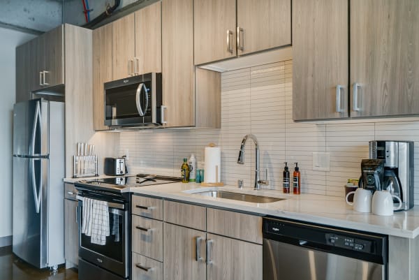 Modern kitchen featuring light wood cabinets and stainless steel appliances.
