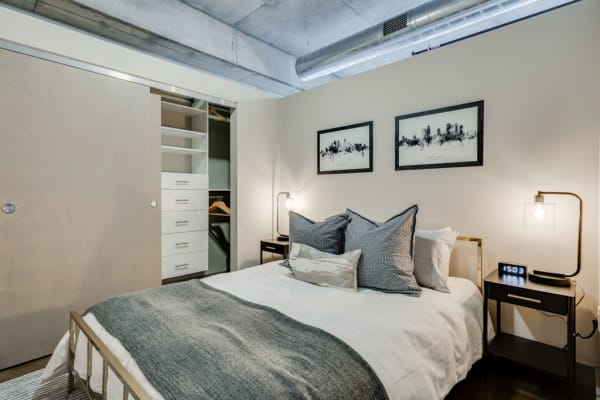 A minimalist bedroom with a queen-sized bed, stylish nightstands, and a sliding door closet.