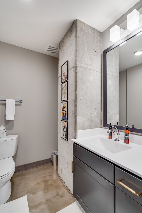 Modern bathroom with a concrete column, framed artwork, and minimalist decor.