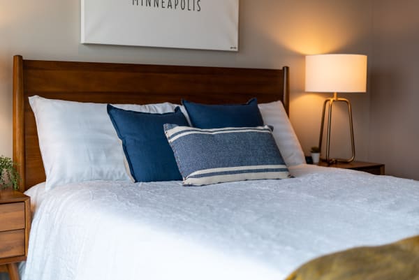 A beautifully arranged bedroom with a wooden headboard and decorative pillows.