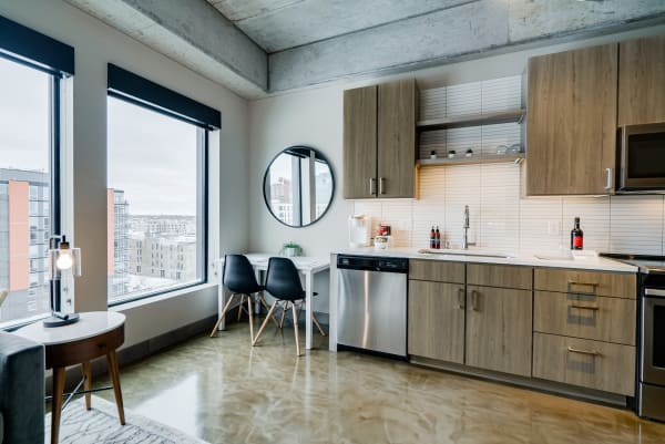 A modern kitchen and dining area featuring large windows, sleek appliances, and contemporary decor.
