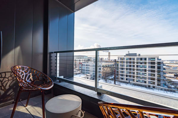 Modern balcony with city view and stylish chairs.