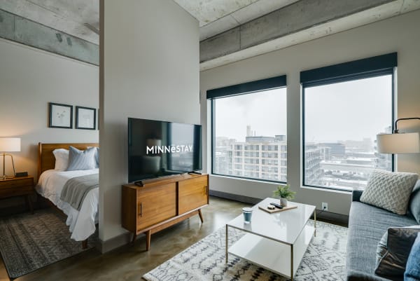 Stylish living area with a bedroom, living room furniture, and snowy city view outside the window.