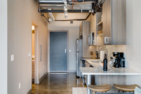 Contemporary kitchen with wooden cabinets and polished concrete flooring.