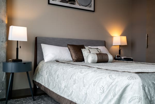 A modern bedroom setup with a neatly made bed and soothing lighting.