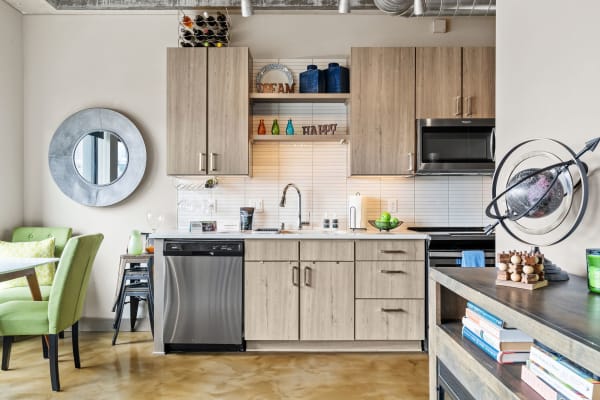 Modern kitchen in an apartment with light wood cabinetry and colorful decorative items.