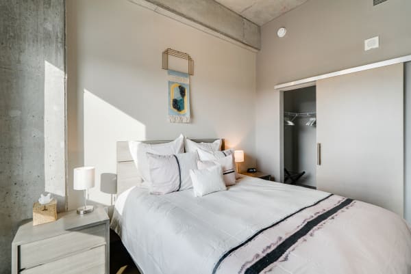 A stylish bedroom with a comfortable bed, soft pillows, and warm lighting.