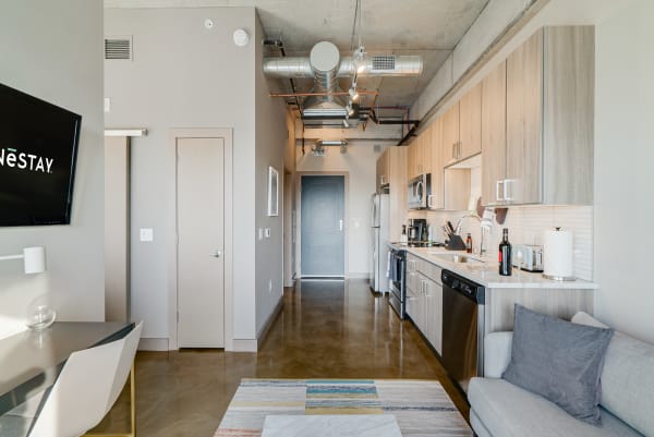 Modern apartment interior featuring a spacious kitchen and living room with industrial elements.