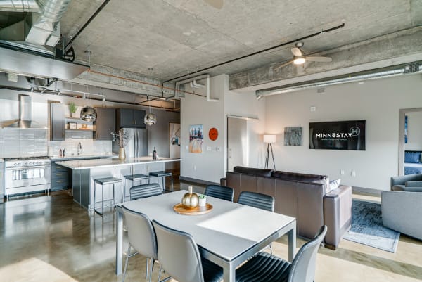 Modern apartment living space with kitchen and dining area, showcasing an industrial design.