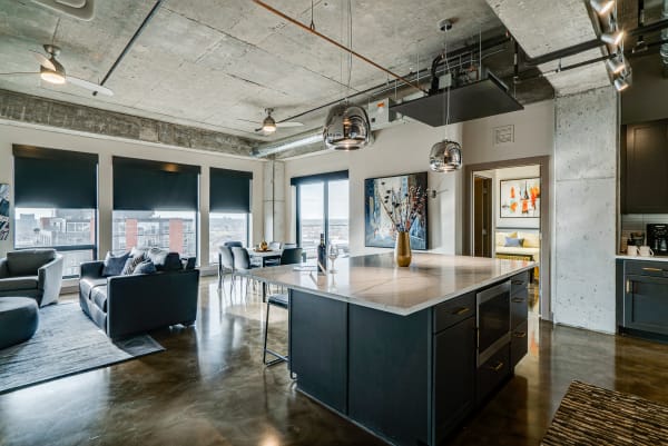 Contemporary open kitchen and living area featuring a marble island and dark cabinetry.