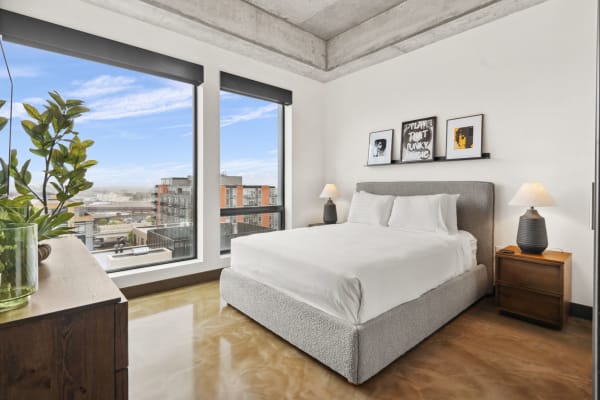 Bright and modern bedroom with large windows, king-sized bed, and minimalist decor.