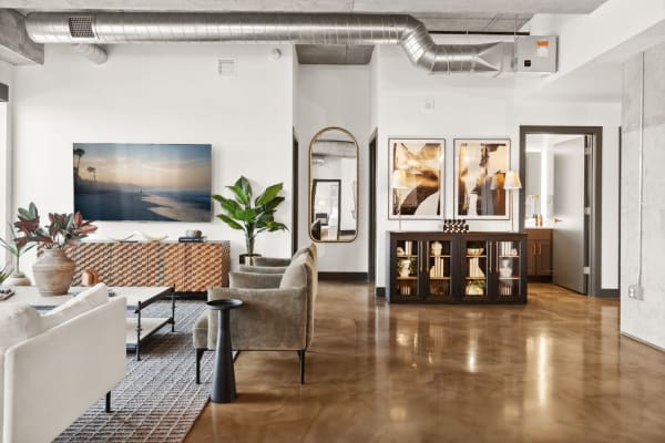 Modern living room with stylish furniture and a beach scene on the TV.