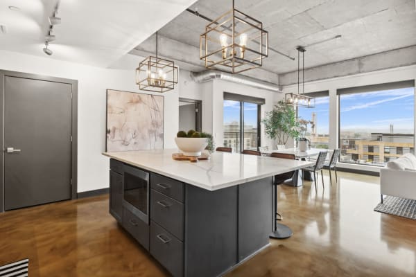 A contemporary kitchen and dining space with marble accents and large windows.