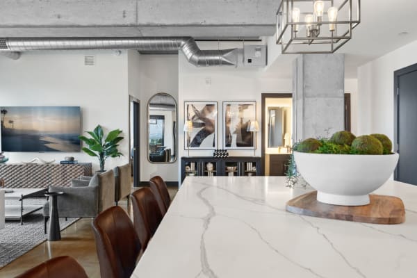 Modern living area with kitchen island, leather bar stools, and contemporary decor.