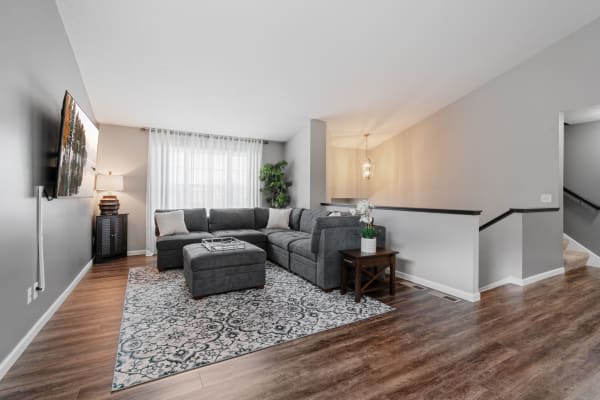 Cozy living room with gray sectional sofa, area rug, and decorative lighting.