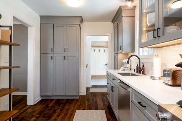 Stylish modern kitchen with gray cabinets and white countertops.