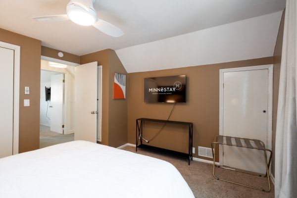 Interior view of a stylish bedroom with a television and contemporary artwork.