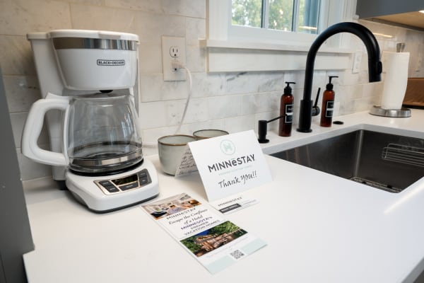 Kitchen countertop featuring a Black+Decker coffee maker and a thank-you note from Minnestay.