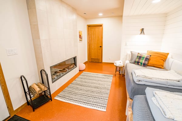 A cozy interior with a fireplace, couch, and decorative elements.